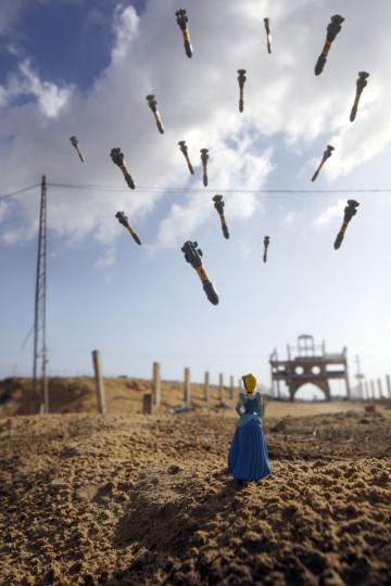 photo d'un ciel bleu , bombes, missiles largués sur une route de terre avec une miniature de la belle au bois dormant de dos