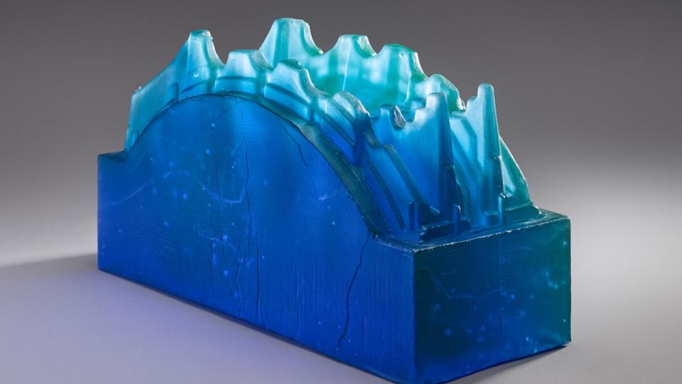 objet en verre bleu avec ondulations vagues sur le haut ressemble à un pont