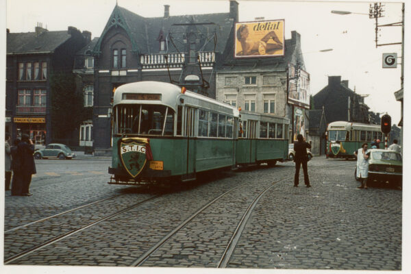 vielle phot avec un tram tramway vert route pavée ancienne maison
